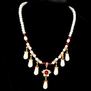Retro pearl tassel necklace with red rhinestones & gold tone flower trim.